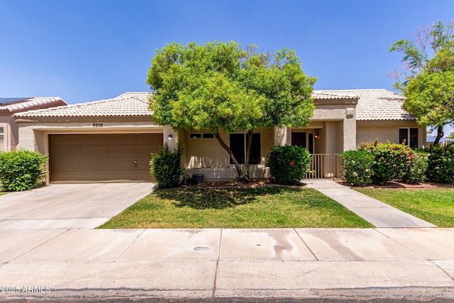 9002 W Caribbean Ln, Peoria, AZ 85381 - view of front facade featuring stucco siding, a garage, a tile roof, concrete driveway, and a front lawn