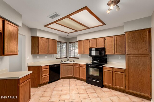 9002 W Caribbean Ln, Peoria, AZ 85381 - kitchen featuring black appliances, a sink, brown cabinetry, light countertops, and light tile patterned flooring