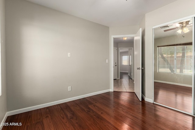 9002 W Caribbean Ln, Peoria, AZ 85381 - unfurnished bedroom featuring a closet, dark wood-style floors, and baseboards