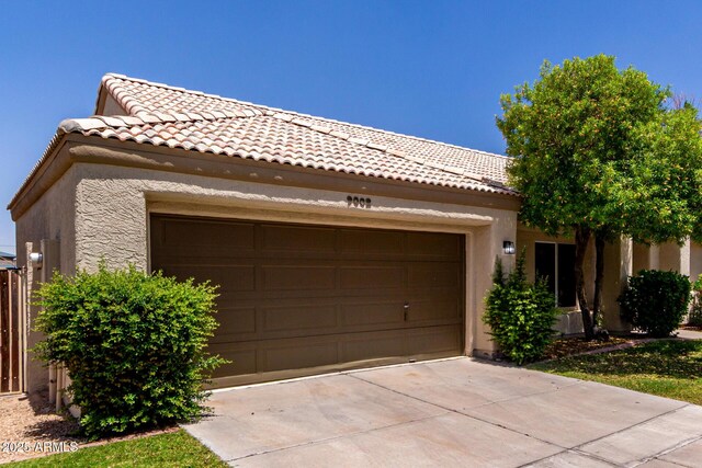 9002 W Caribbean Ln, Peoria, AZ 85381 - view of front of property featuring stucco siding, a tiled roof, a garage, and concrete driveway