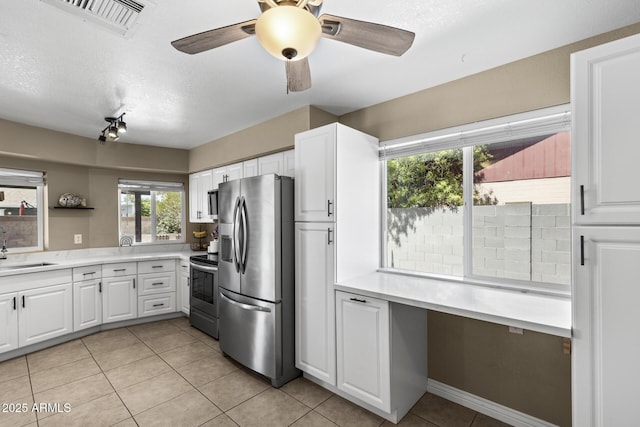 6605 W Altadena Ave, Glendale, AZ 85304 - kitchen with appliances with stainless steel finishes, light tile patterned floors, white cabinetry, light countertops, and a textured ceiling