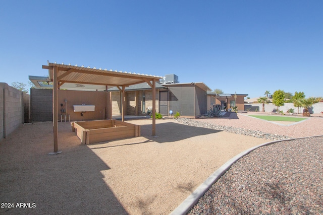 back of house featuring a pergola and central AC unit