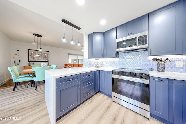 15225 N 100th St Unit 1185, Scottsdale, AZ 85260 - kitchen with stainless steel appliances, a peninsula, light wood-style flooring, and blue cabinets