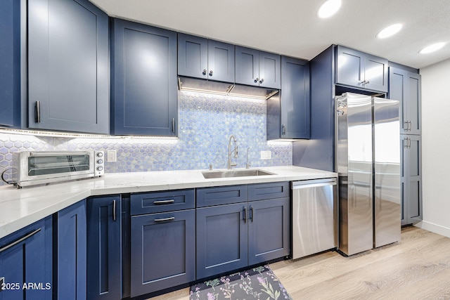 15225 N 100th St Unit 1185, Scottsdale, AZ 85260 - kitchen with appliances with stainless steel finishes, light wood finished floors, blue cabinetry, backsplash, and recessed lighting