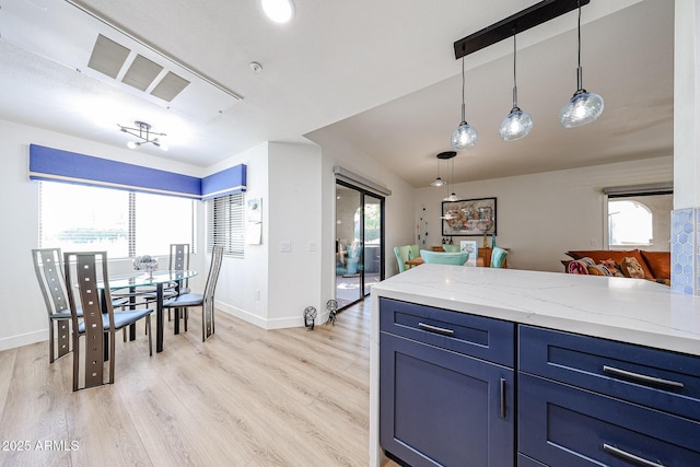 15225 N 100th St Unit 1185, Scottsdale, AZ 85260 - kitchen featuring blue cabinetry, light wood-style flooring, a peninsula, hanging light fixtures, and light stone countertops