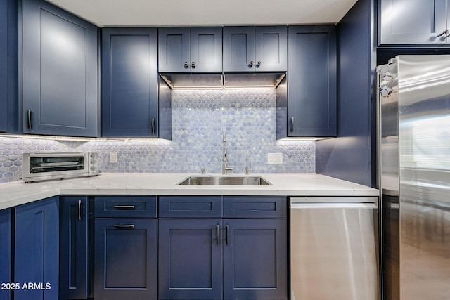 15225 N 100th St Unit 1185, Scottsdale, AZ 85260 - kitchen featuring stainless steel appliances, blue cabinetry, decorative backsplash, and light stone countertops