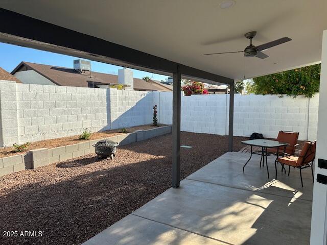 view of patio / terrace featuring a fenced backyard, ceiling fan, and an outdoor fire pit