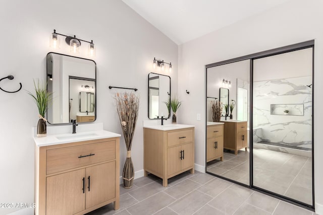 bathroom with vaulted ceiling, two vanities, a marble finish shower, and a sink