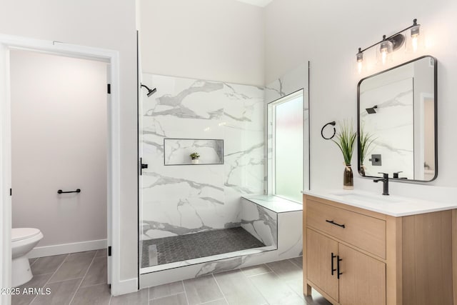 bathroom with a marble finish shower, toilet, and vanity