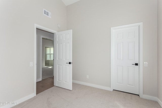 unfurnished bedroom with baseboards, visible vents, and light carpet