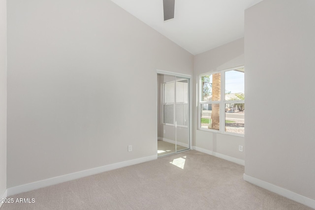 unfurnished bedroom with light colored carpet, baseboards, a closet, and high vaulted ceiling