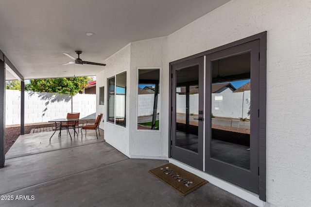 view of patio with outdoor dining space, a ceiling fan, and fence