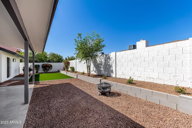 view of yard featuring a patio area, an outdoor fire pit, and a fenced backyard