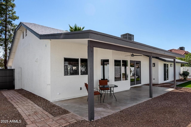 rear view of property with stucco siding, fence, cooling unit, and a patio area