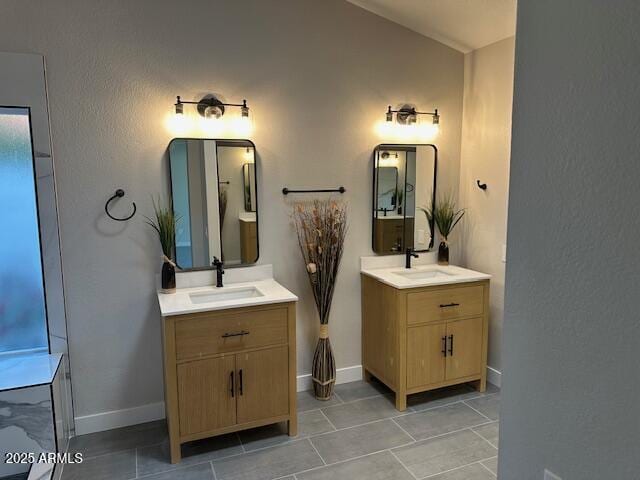 full bath with a sink, two vanities, and tile patterned floors
