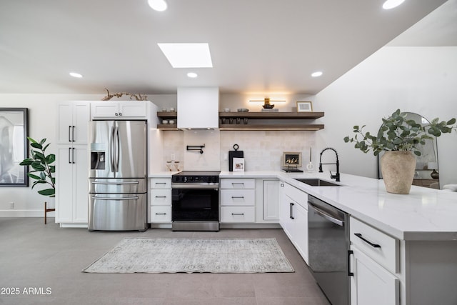 kitchen featuring a sink, wall chimney range hood, appliances with stainless steel finishes, a peninsula, and open shelves