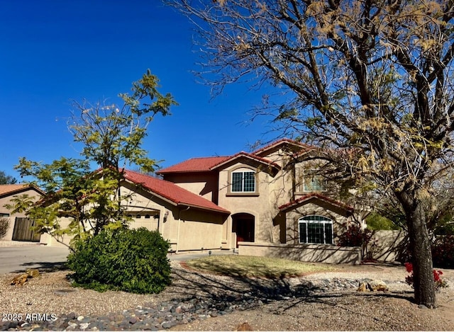 view of front of house featuring a garage, fence, stucco siding, and a tile roof