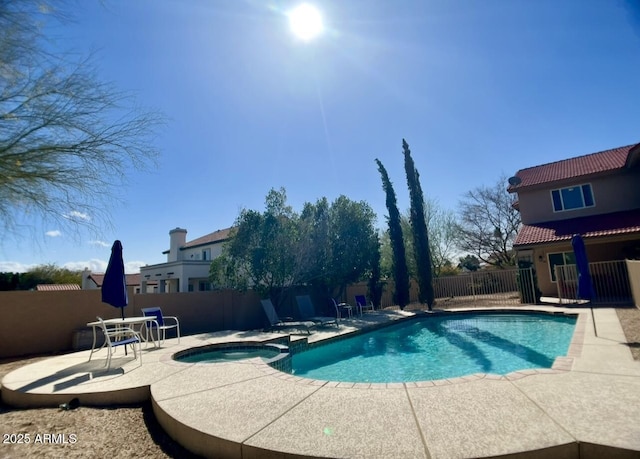 view of pool featuring a patio, a fenced backyard, and a pool with connected hot tub