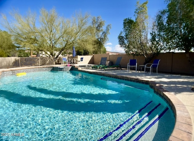 view of swimming pool featuring a patio, fence, and a fenced in pool