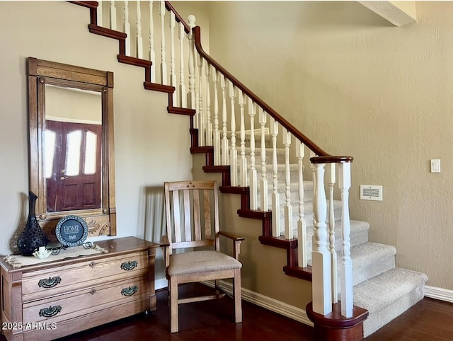 stairs featuring visible vents, baseboards, and wood finished floors