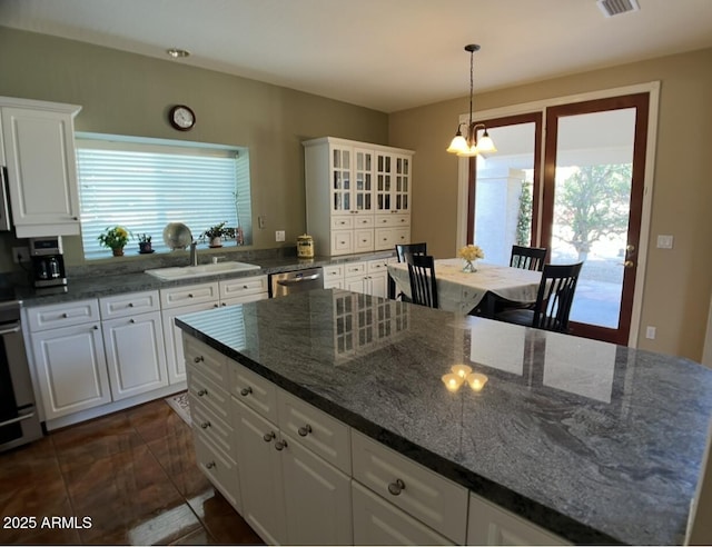 kitchen featuring dishwasher, white cabinetry, an inviting chandelier, and a sink