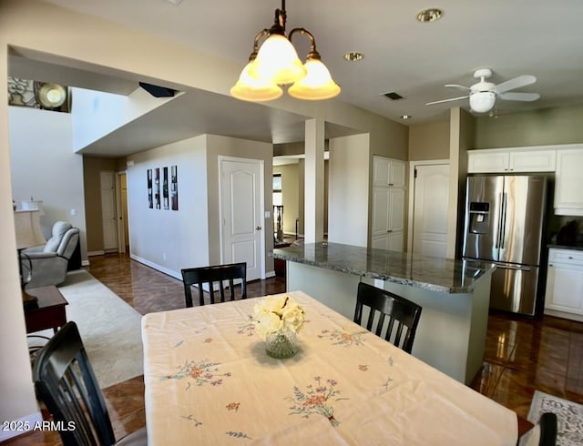 dining space with baseboards, visible vents, and ceiling fan