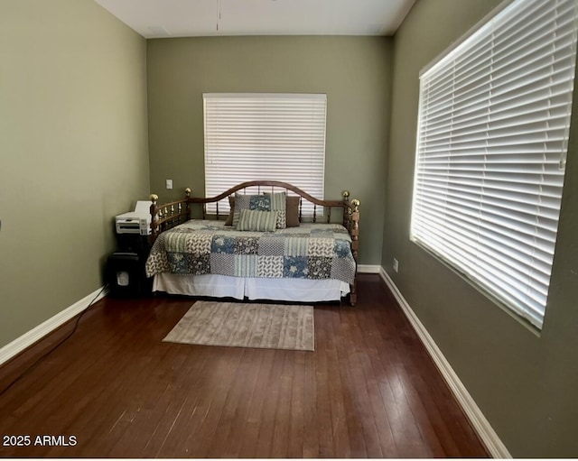 bedroom featuring hardwood / wood-style flooring and baseboards