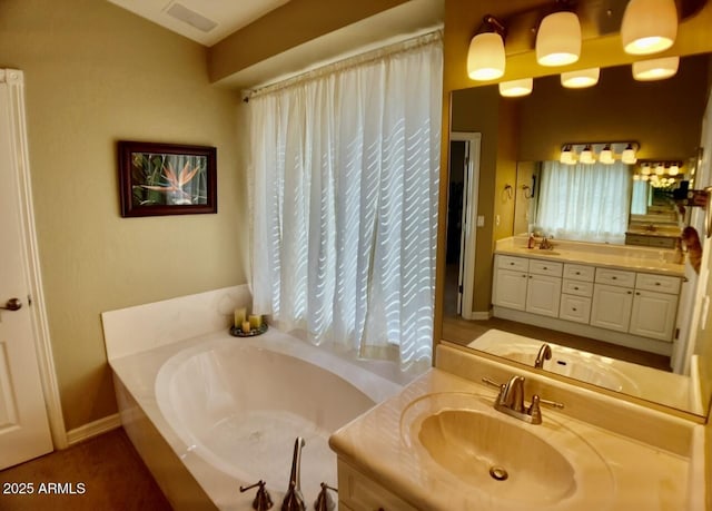 full bathroom featuring visible vents, baseboards, a bath, and vanity