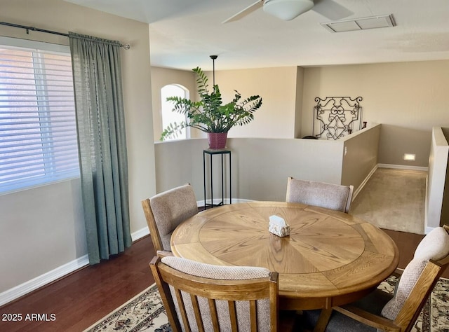 dining room with a wealth of natural light, a ceiling fan, baseboards, and wood finished floors