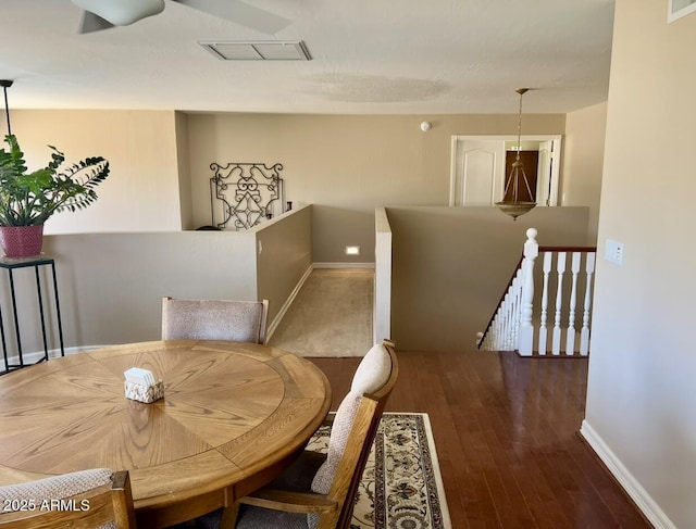 dining room featuring visible vents, baseboards, and wood finished floors