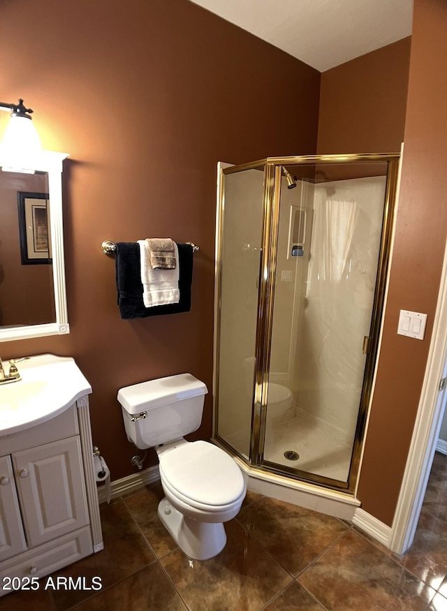 bathroom featuring tile patterned flooring, toilet, a stall shower, and vanity