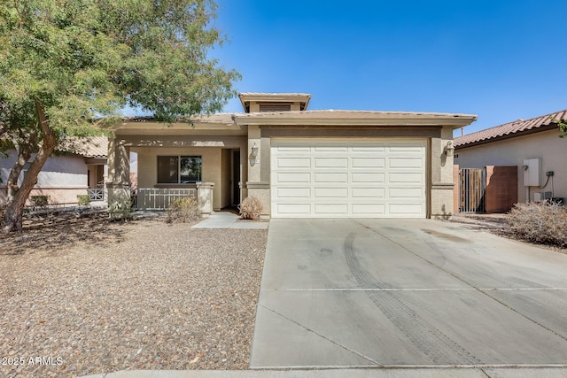 view of front facade with a garage, fence, concrete driveway, and stucco siding