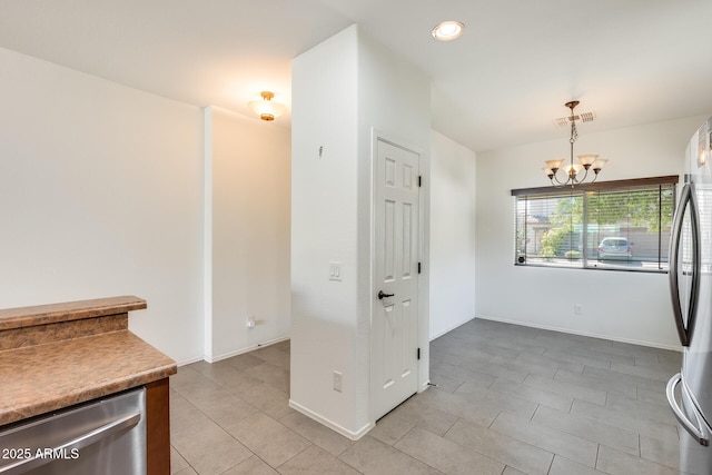 unfurnished dining area with light tile patterned floors, baseboards, visible vents, and a notable chandelier