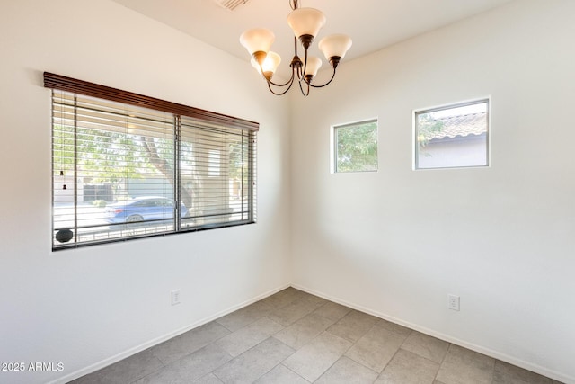 unfurnished room with baseboards and a chandelier