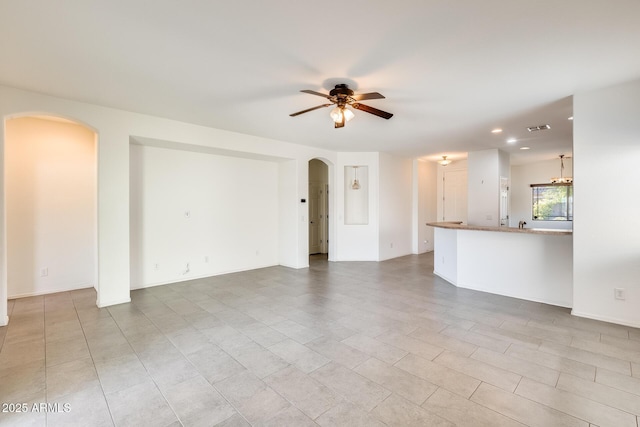 unfurnished living room featuring arched walkways, visible vents, a ceiling fan, and recessed lighting