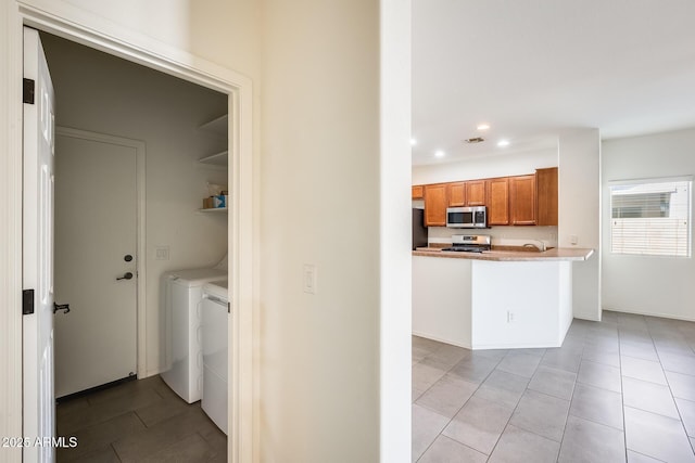 interior space with recessed lighting, separate washer and dryer, visible vents, appliances with stainless steel finishes, and brown cabinetry