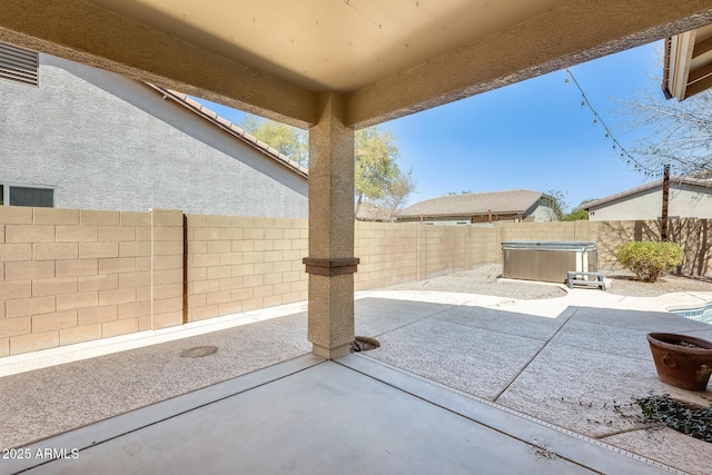 view of patio with a fenced backyard and a hot tub