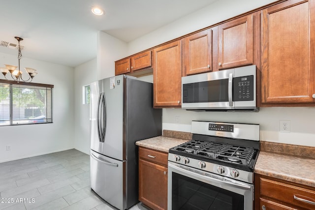 kitchen with visible vents, brown cabinetry, appliances with stainless steel finishes, hanging light fixtures, and a notable chandelier