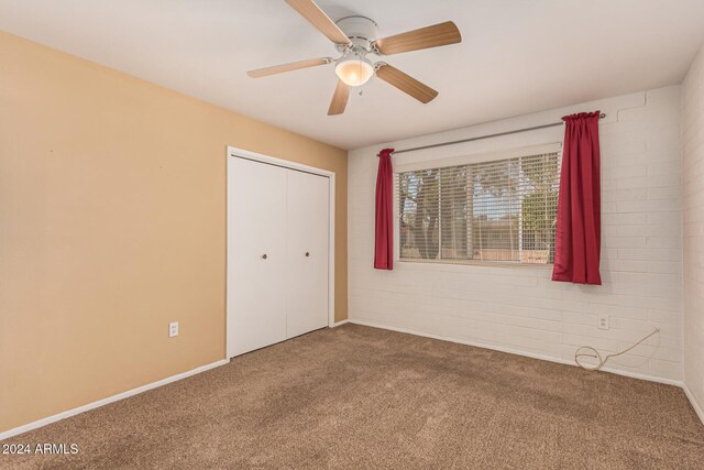 unfurnished bedroom featuring carpet flooring, ceiling fan, and a closet