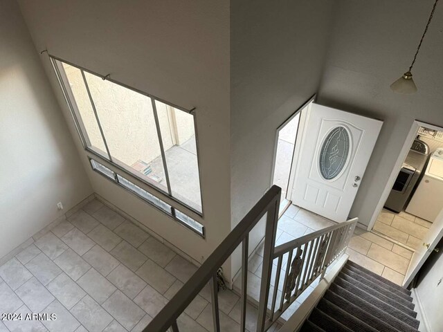 entryway with light tile patterned flooring and high vaulted ceiling