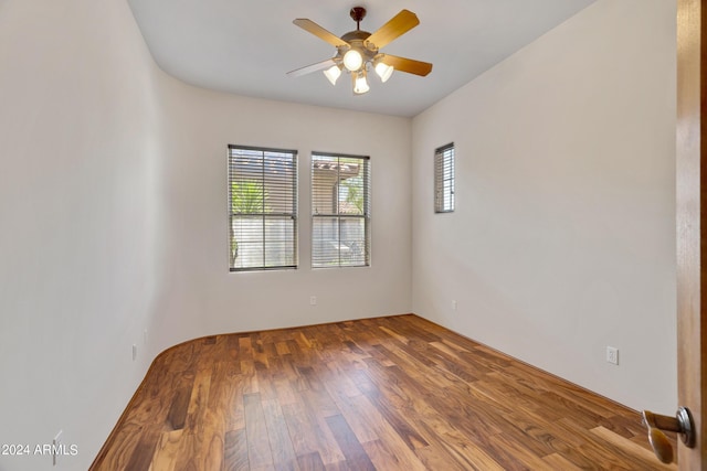 spare room featuring dark wood-type flooring and ceiling fan
