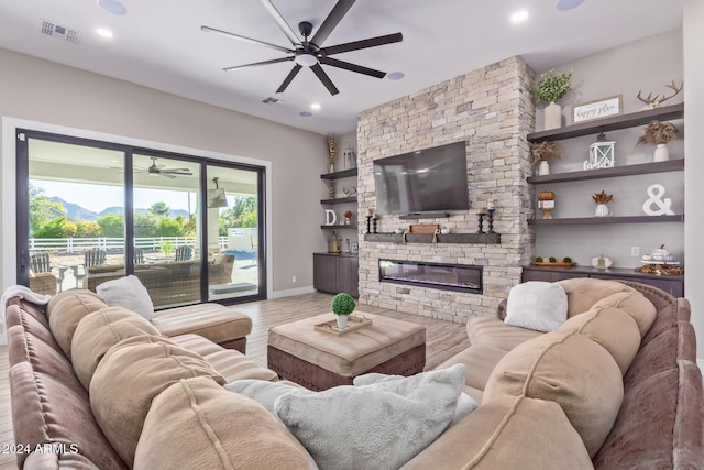 living room with a fireplace, a mountain view, hardwood / wood-style flooring, and built in features