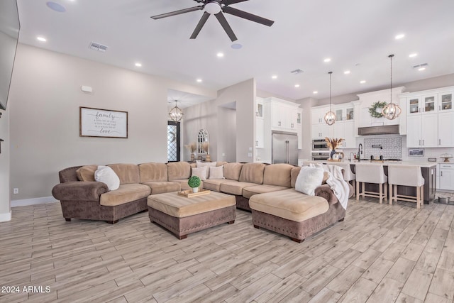 living room with ceiling fan and light wood-type flooring