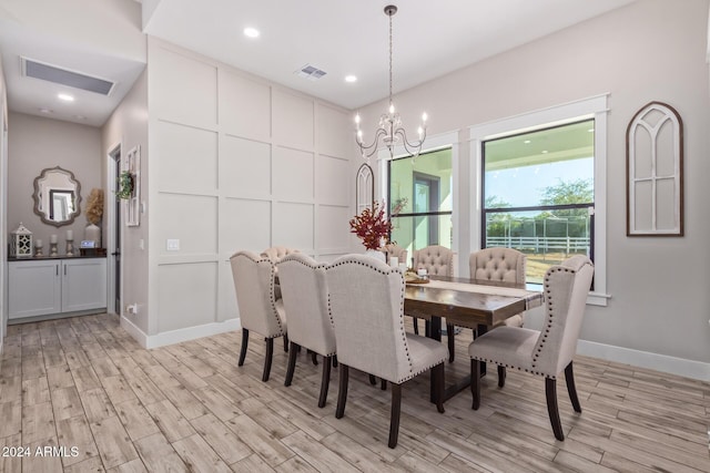 dining space with light wood-type flooring and a chandelier