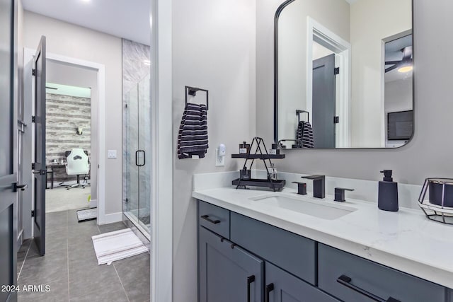 bathroom with tile patterned flooring, vanity, and walk in shower