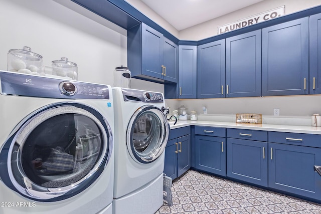 washroom with washer and dryer and cabinets