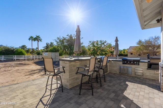 view of patio featuring exterior bar and a grill