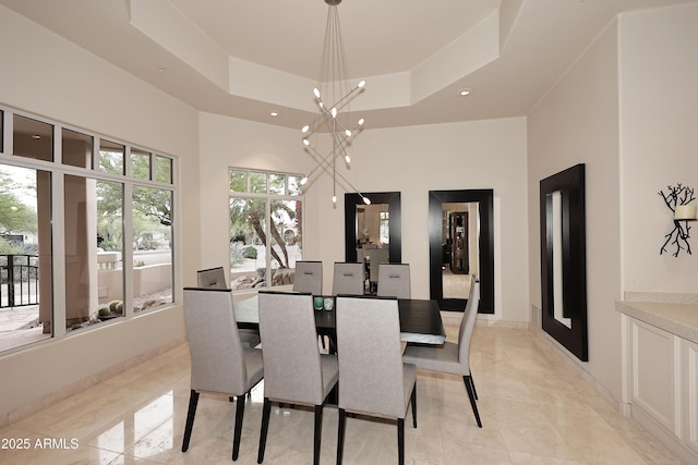 dining area with a raised ceiling, a high ceiling, a notable chandelier, and recessed lighting