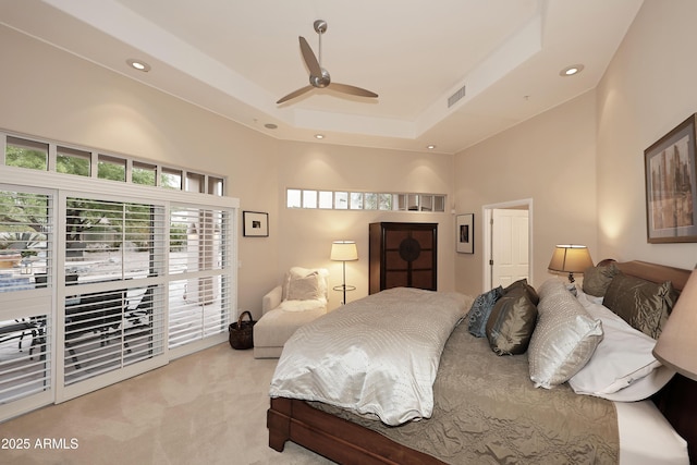 bedroom featuring recessed lighting, visible vents, a raised ceiling, light colored carpet, and access to exterior