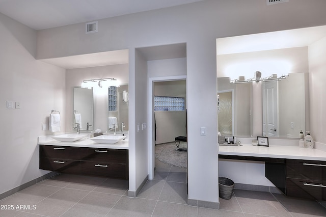 bathroom with a sink, double vanity, visible vents, and tile patterned flooring